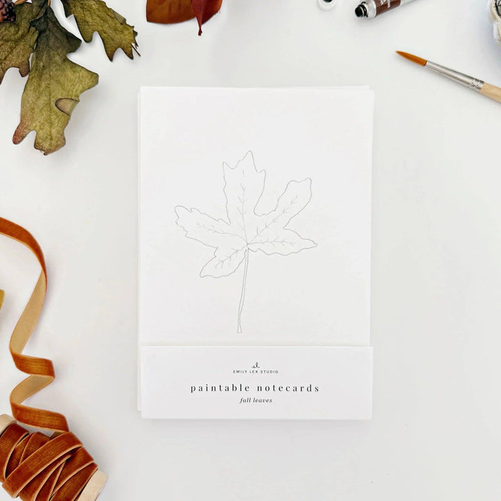 Paintable notecard with leaf design and ribbon on a white surface