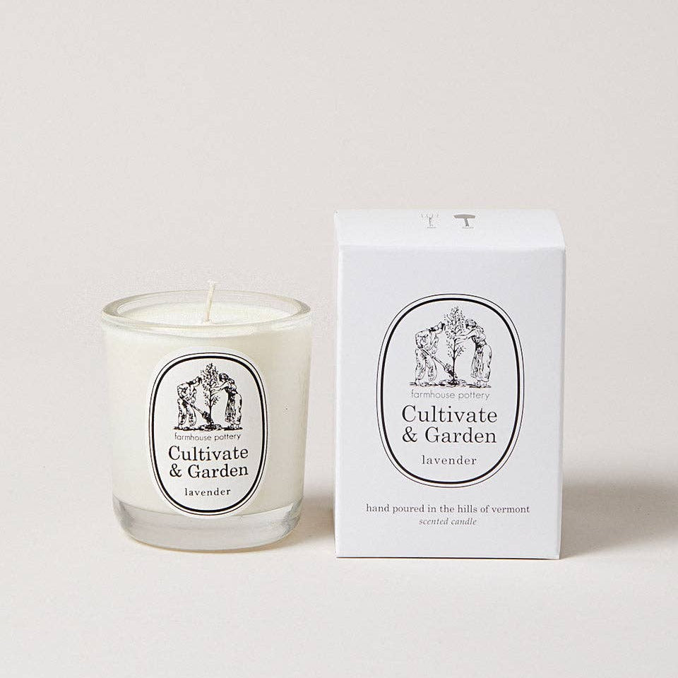 Candle with 'Cultivate & Garden' label next to its packaging on a light background