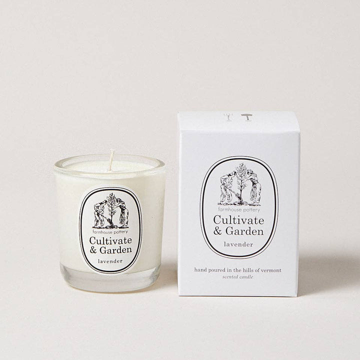 Candle with 'Cultivate & Garden' label next to its packaging on a light background