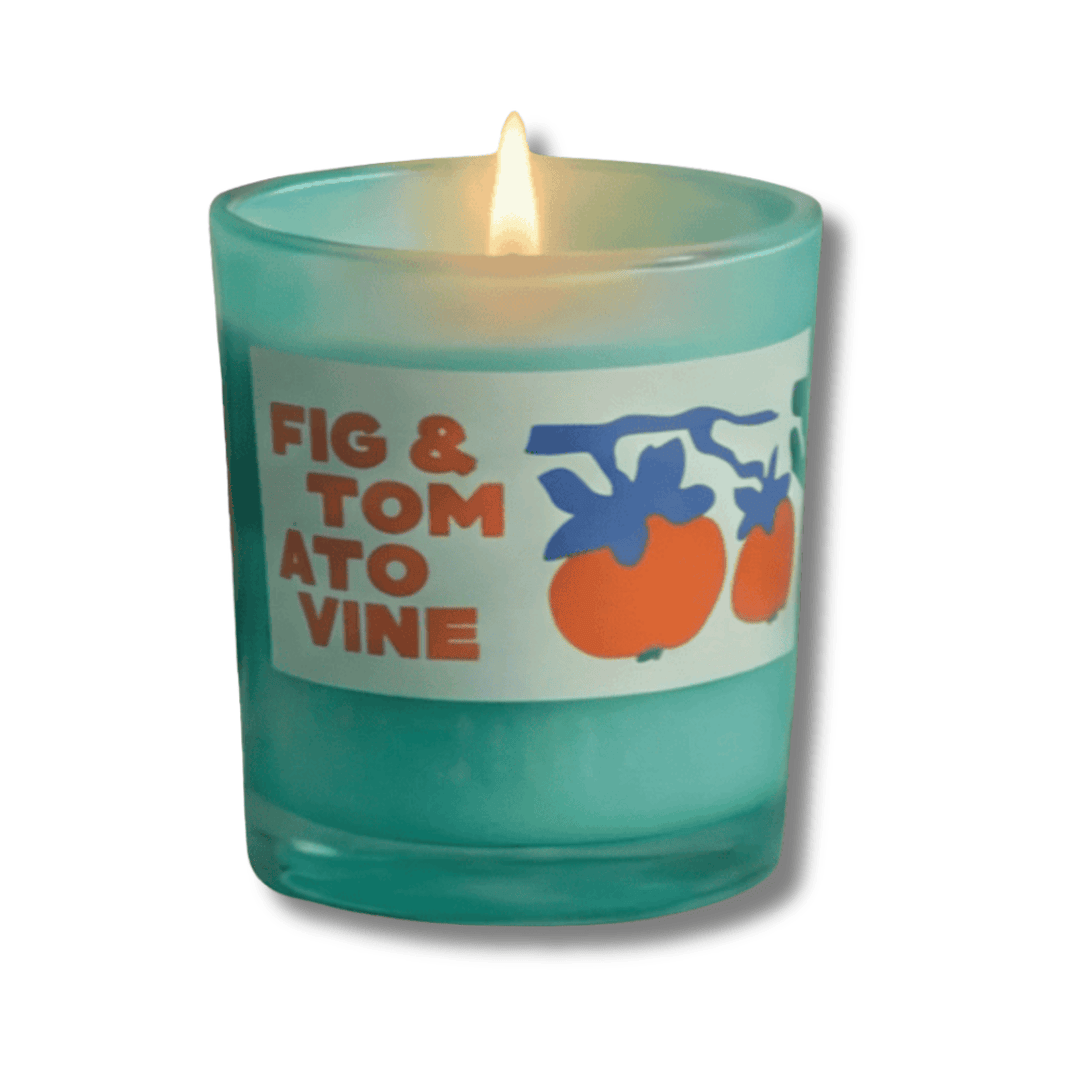 Candle in a teal glass jar with a label reading 'Fig & Tomato Vine' on a white background