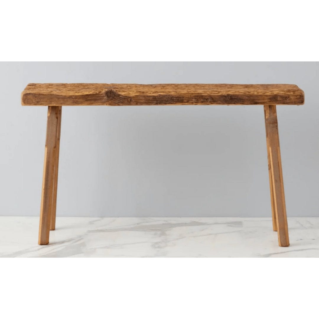 Wooden bench with a natural finish on a marble surface and light gray background