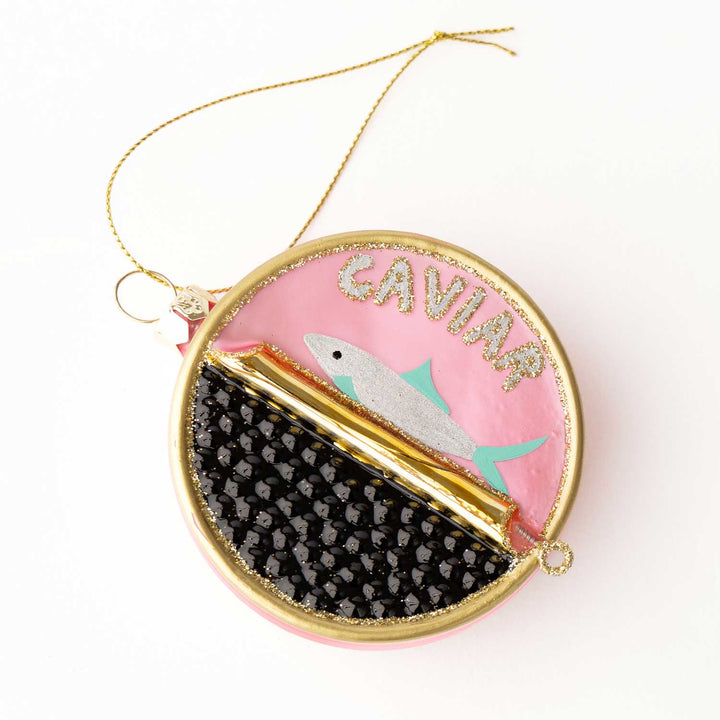 Decorative ornament with fishdesign and 'CAVIAR' text on a pink background