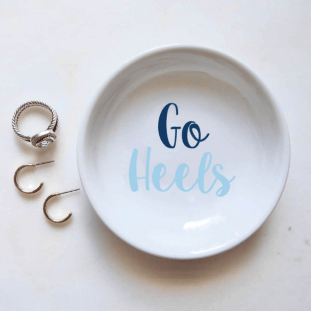 White trinket dish with 'Go Heels' text and rings on a white background