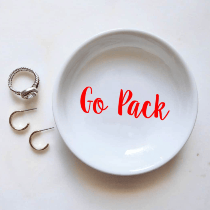 Circular white ring dish with Go Pack vinyl letters