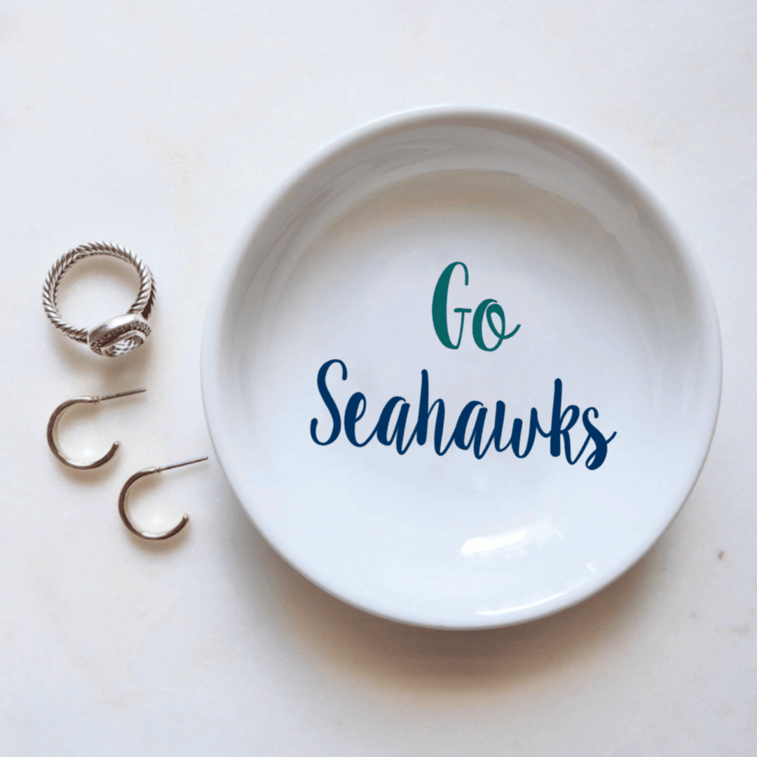 White dish with 'Go Seahawks' text and three rings on a white background