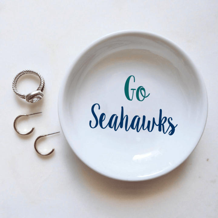 White dish with 'Go Seahawks' text and three rings on a white background