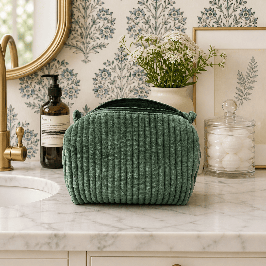 Green textured bag on a marble countertop with decorative elements in the background