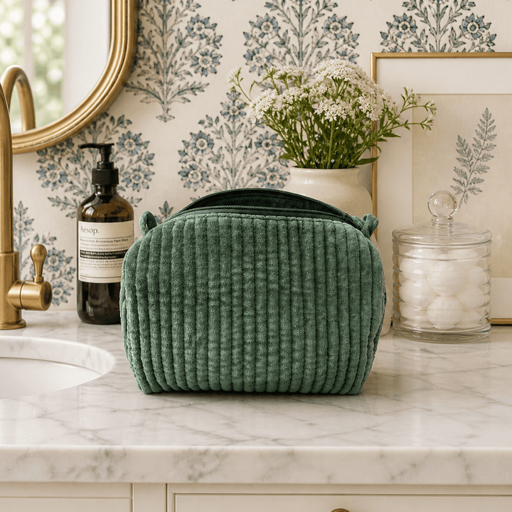 Green textured bag on a marble countertop with decorative elements in the background