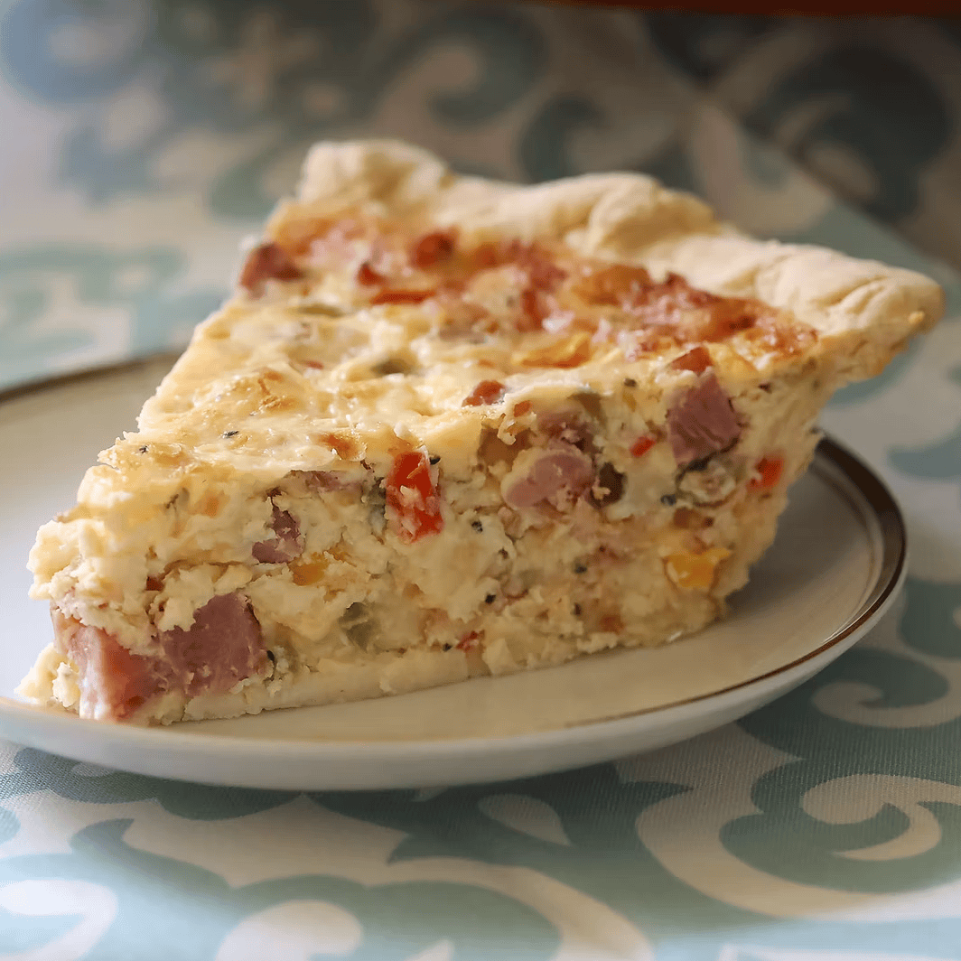 Slice of pie on a plate with a patterned tablecloth