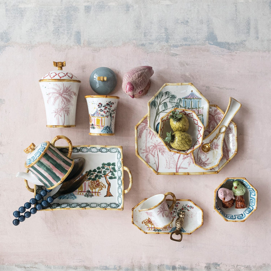 Collection of decorative ceramic items on a textured pink surface