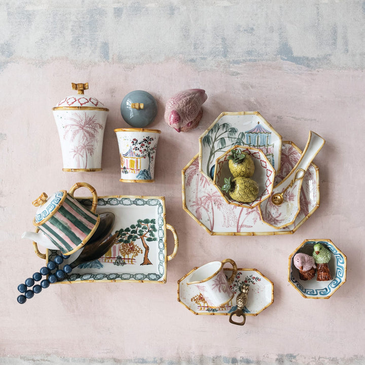 Collection of decorative ceramic items on a textured pink surface