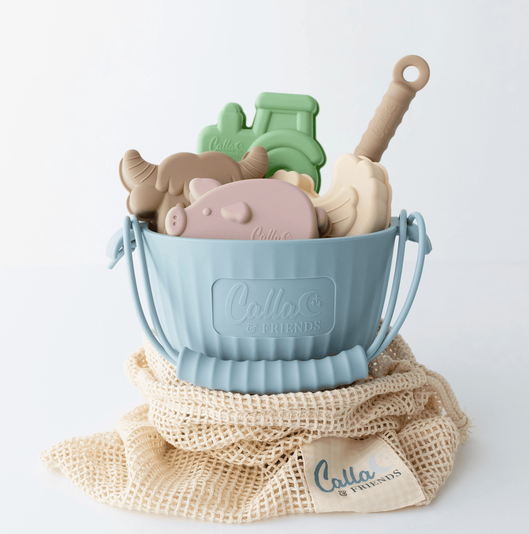 Set of colorful animal-shaped bath toys in a blue bucket with a branded mesh bag on a white background.