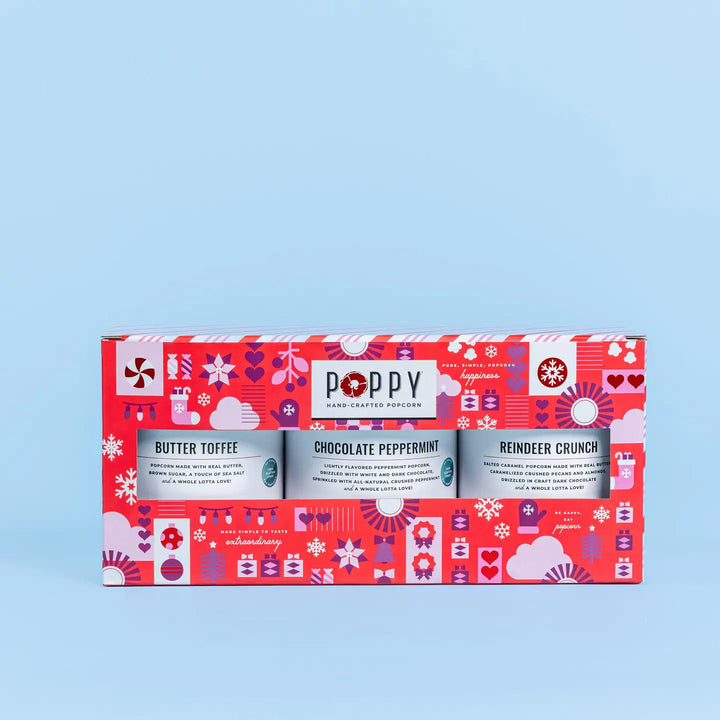 Poppy handcrafted popcorn gift set with three flavors on a red box against a light blue background