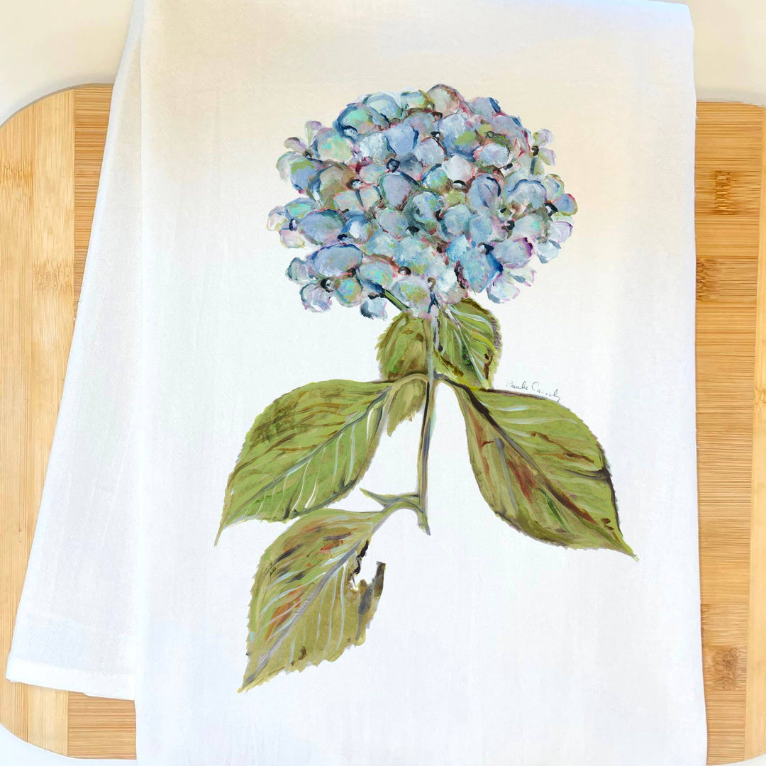 White towel with a blue hydrangea design on a wooden surface