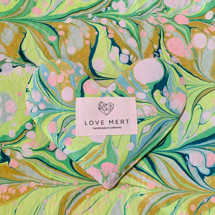 Marbled paper with an eye pillow in pink, green, and blue colors and a 'Love Mert' label.