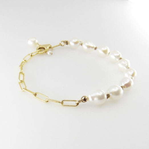 Pearl bracelet with gold chain on a white background