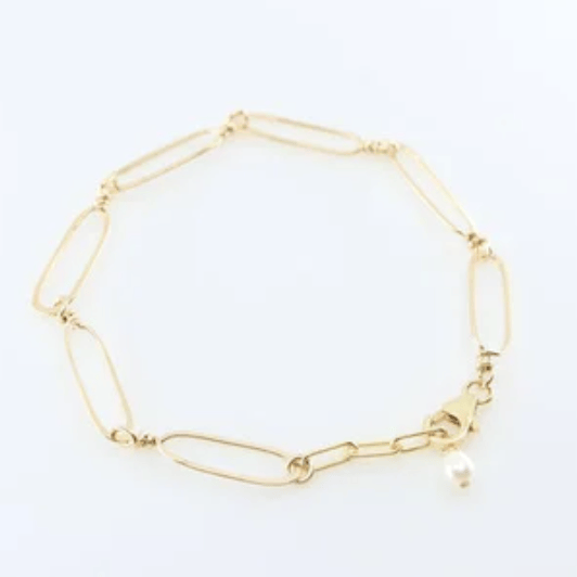 Forged gold paperclip link bracelet with pearl accent on a white background