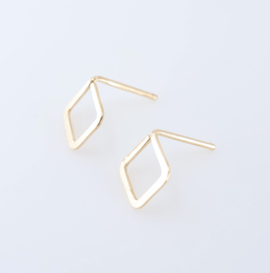 Tiny forged gold diamond shaped stud earrings on white background.