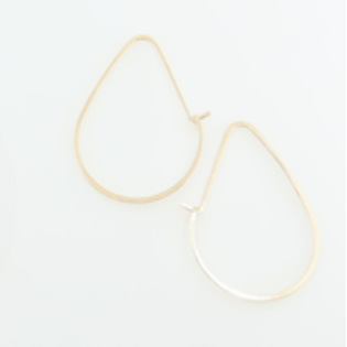 Gold hoop earrings on a light beige background