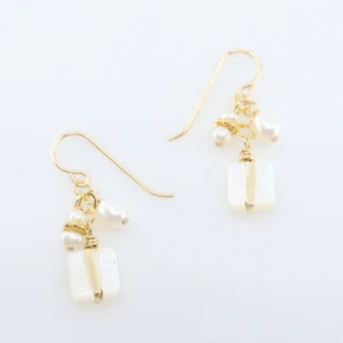 Gold earrings with pearl-like beads on a white background