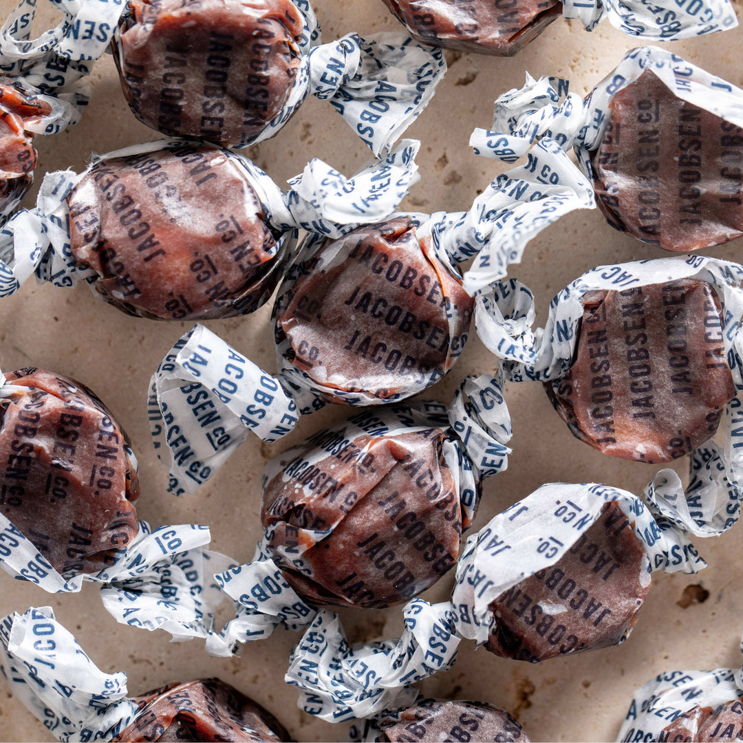 Assorted candies in paper wrappers on a cardboard surface
