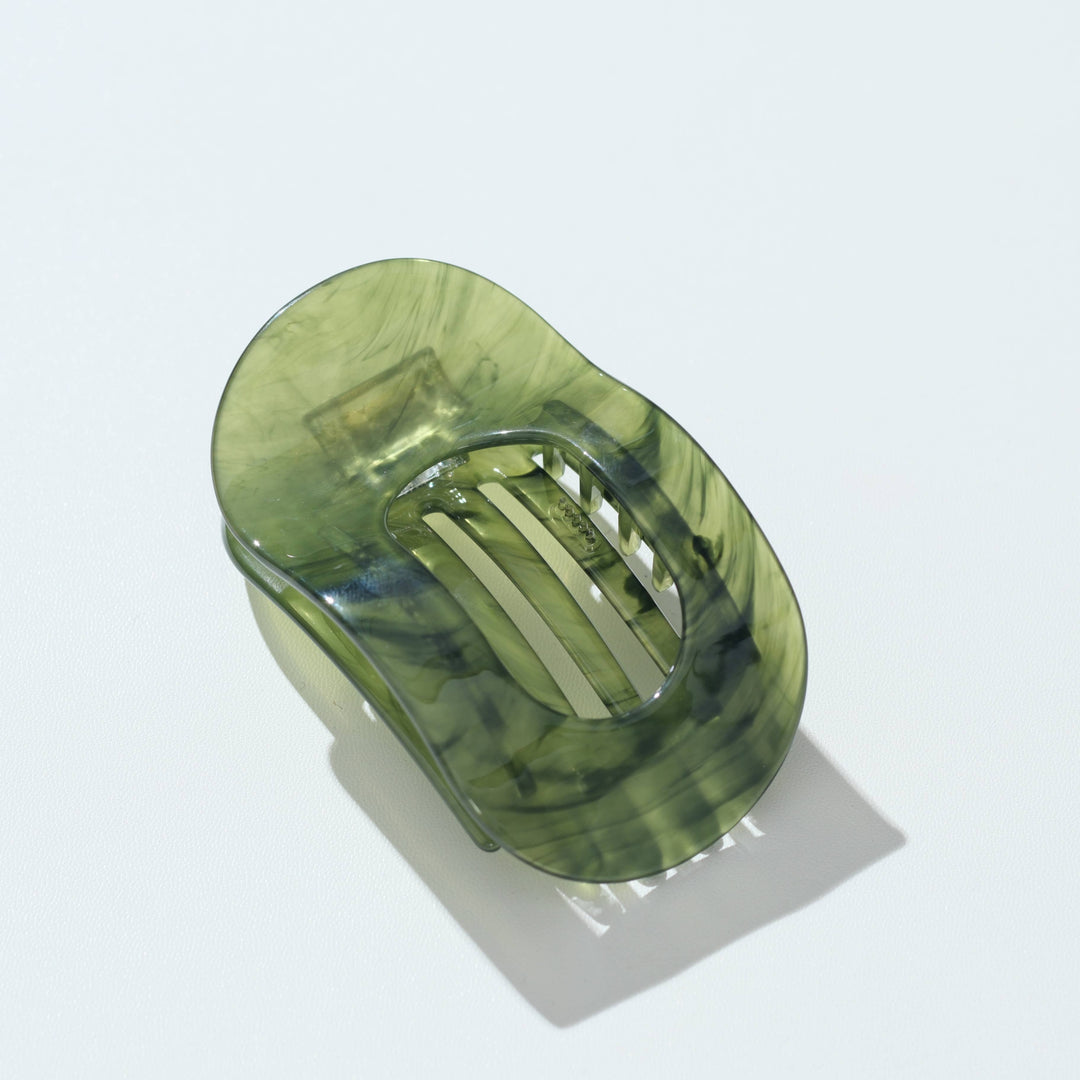 A translucent olive green hair claw clip with a marbled pattern, shown on a clean white background with a soft shadow.