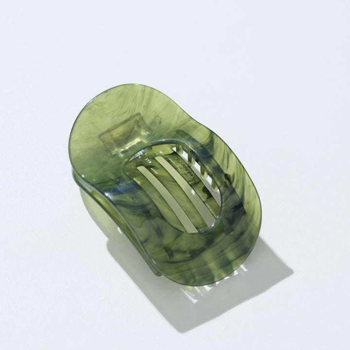 A translucent olive green hair claw clip with a marbled pattern, shown on a clean white background with a soft shadow.