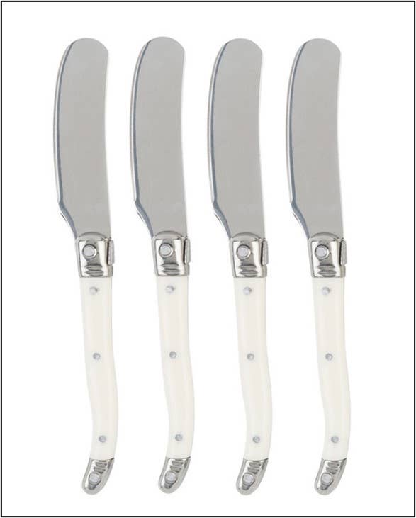 Four cheese spreaders with faux ivory handles and silver blades on a white background