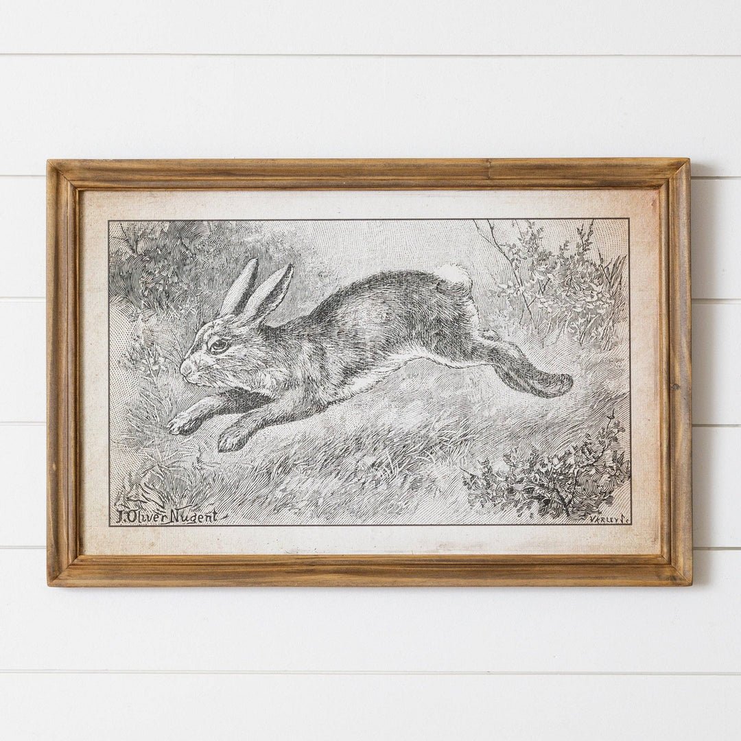 Framed black and white illustration of a rabbit on a wooden surface