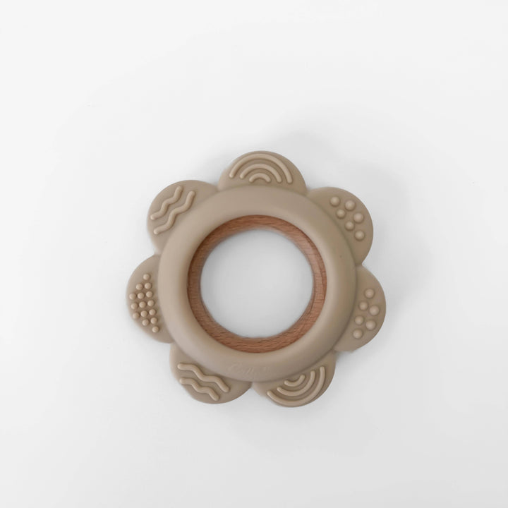 Beige teething ring with wooden center on a white background