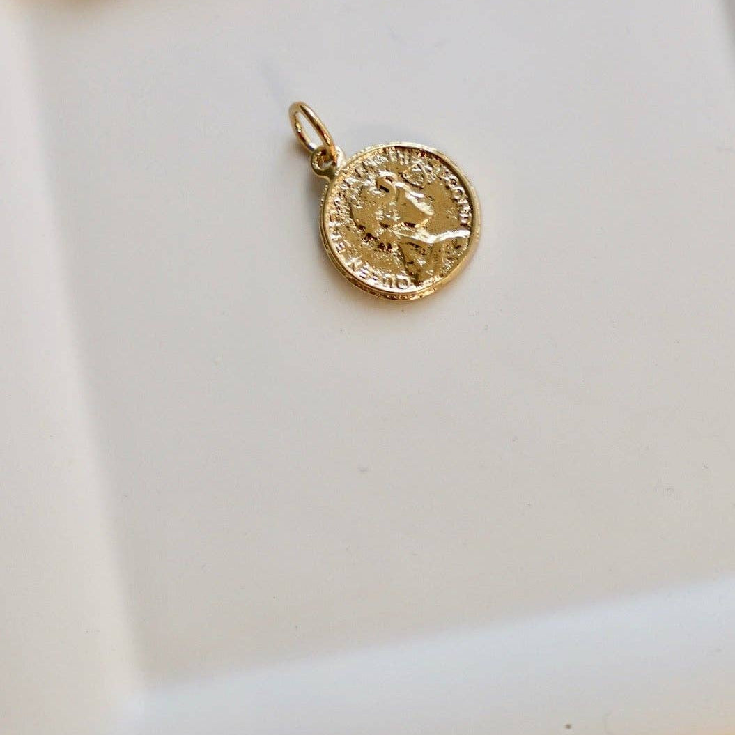 Gold pendant on a white ceramic dish with a bow
