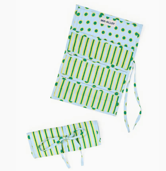A fabric organizer pouch with a mint green and orange striped pattern, featuring a small gold floral motif and a visible 'INK-ALLOY' brand label. The pouch is shown both open and rolled up on a clean white background.
