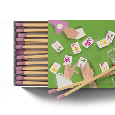 Matchbox with wooden matches and playing cards on a green background