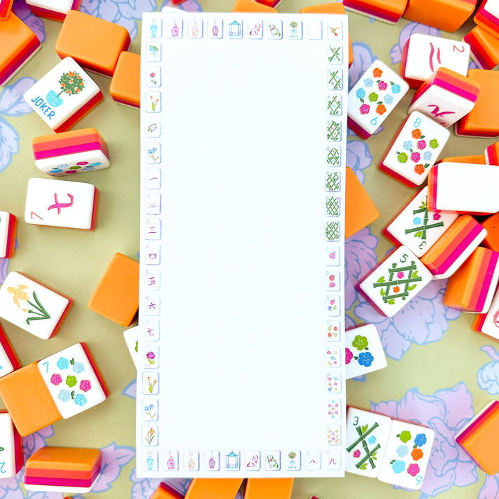 Mahjong notepad and Colorful game tiles with various designs on a light green background