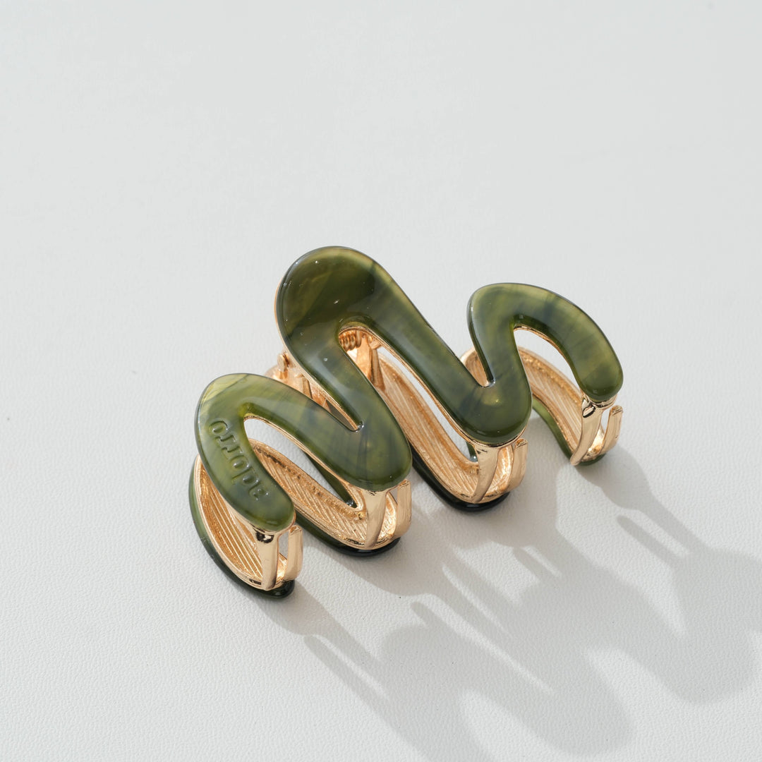 Jade Green and gold claw hair clip on a light gray background