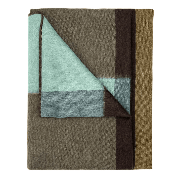 A folded wool blanket with a block pattern in brown, beige, and light mint green, with one corner turned over to show the reverse side, on a plain white background.