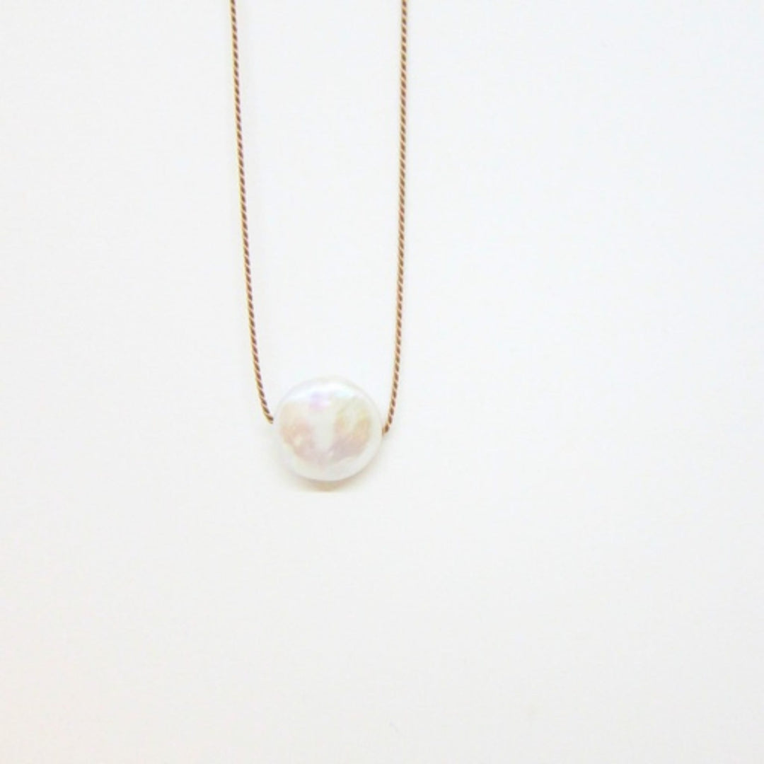 Circular pearl charm on silk cord