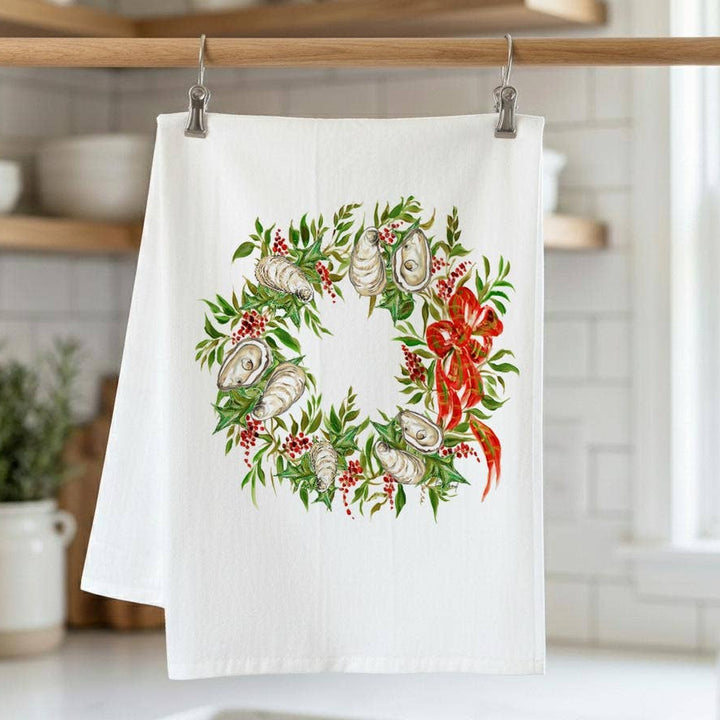Decorative kitchen towel with a wreath design hanging on a rack.