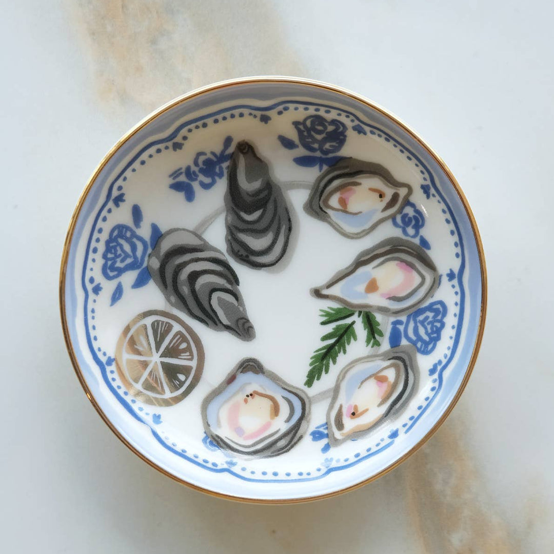 Decorative plate with oyster shells and lemon slices on a white background