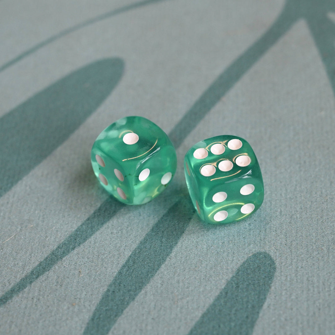 Two green dice with white dots on a textured green surface