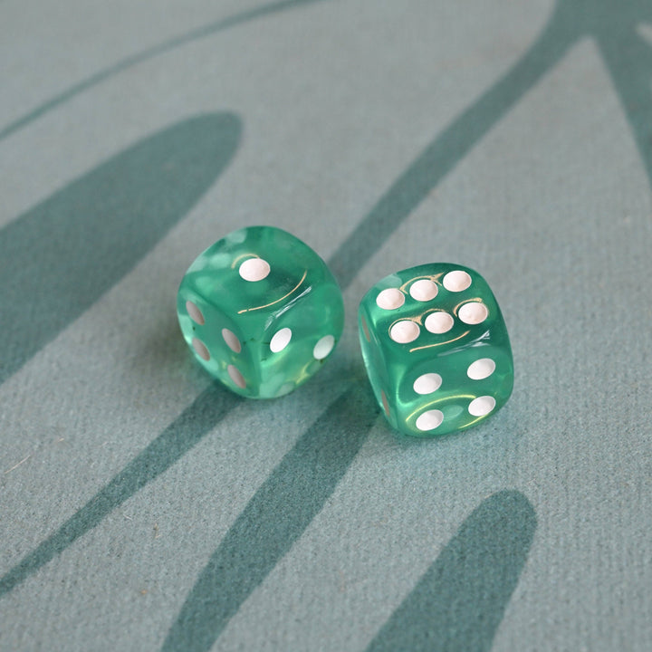 Two green dice with white dots on a textured green surface