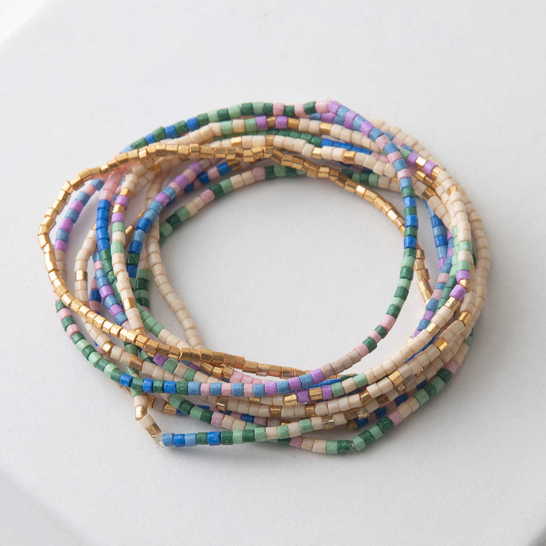 Set of colorful beaded bracelets on a white surface