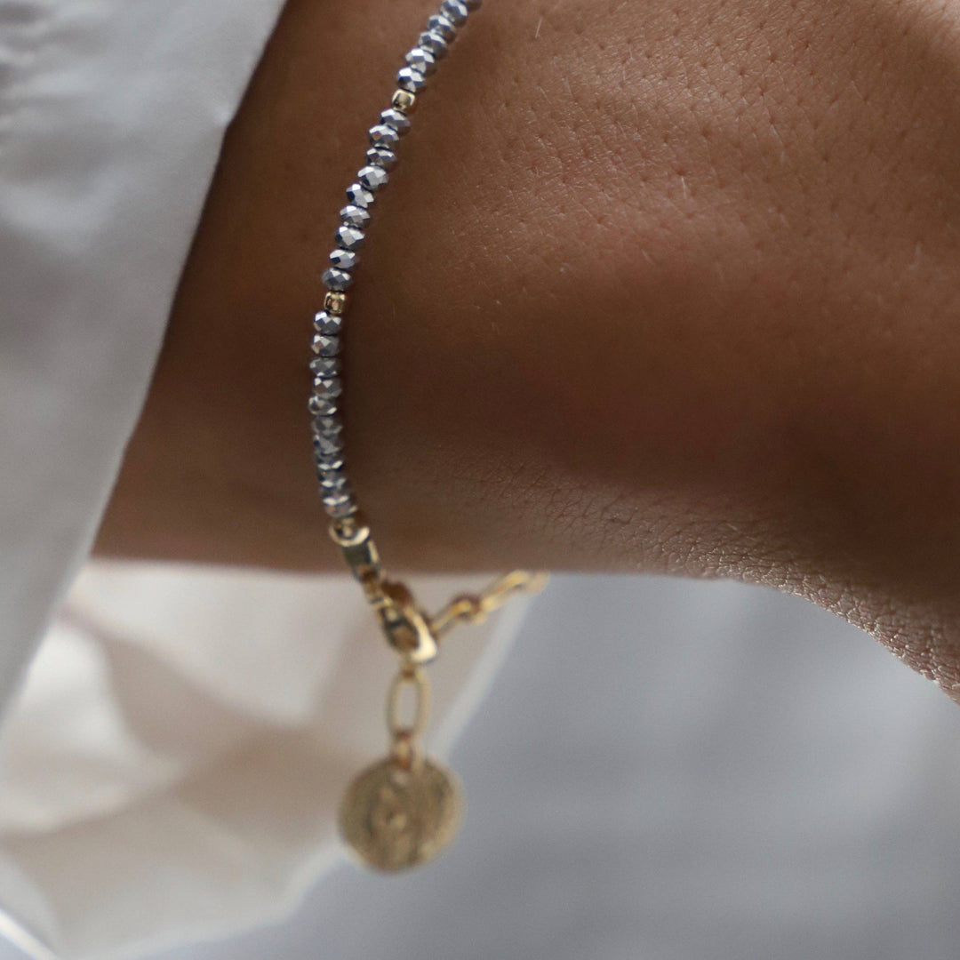 Close-up of a wrist wearing two bracelets on a white background