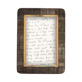 This photo frame is perfect for displaying your favorite memories. Hand-carved, this frame is made out of horn, and features a black and natural color and brass border that matches with any decor styles.