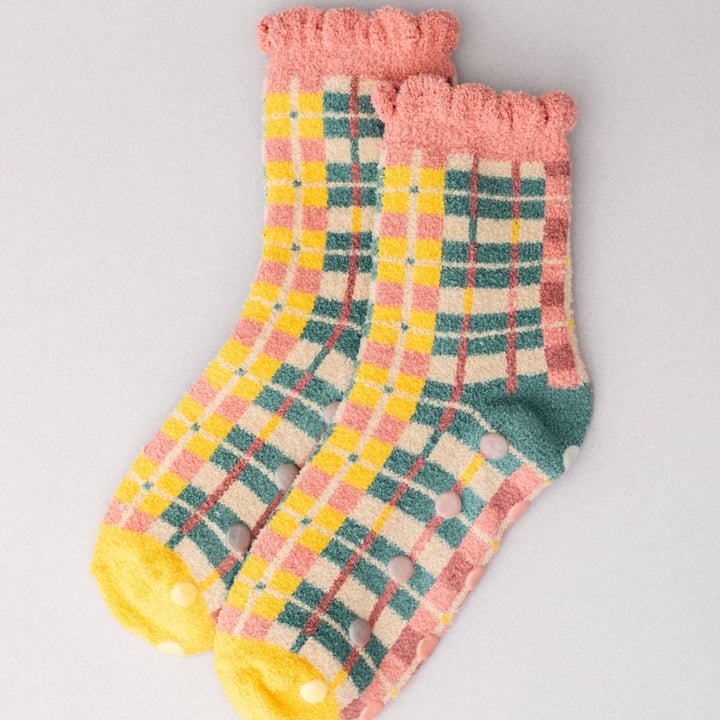 Pair of checkered socks with pink cuffs on a light gray background