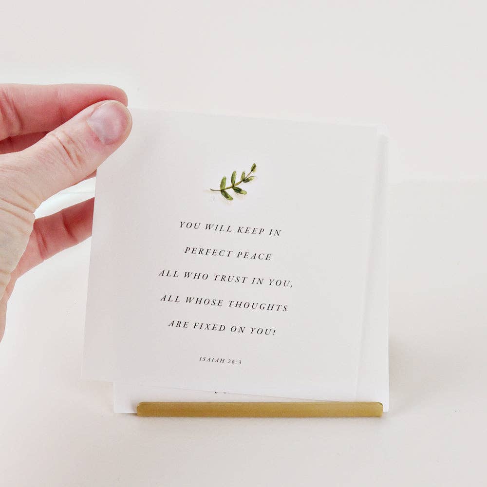 Hand holding a card with a motivational quote on a white background