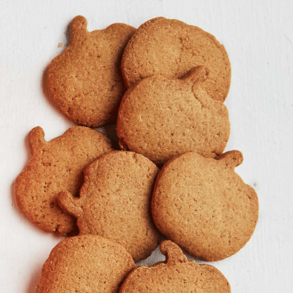 A pile of pumpkin-shaped cookies on a plain white background.