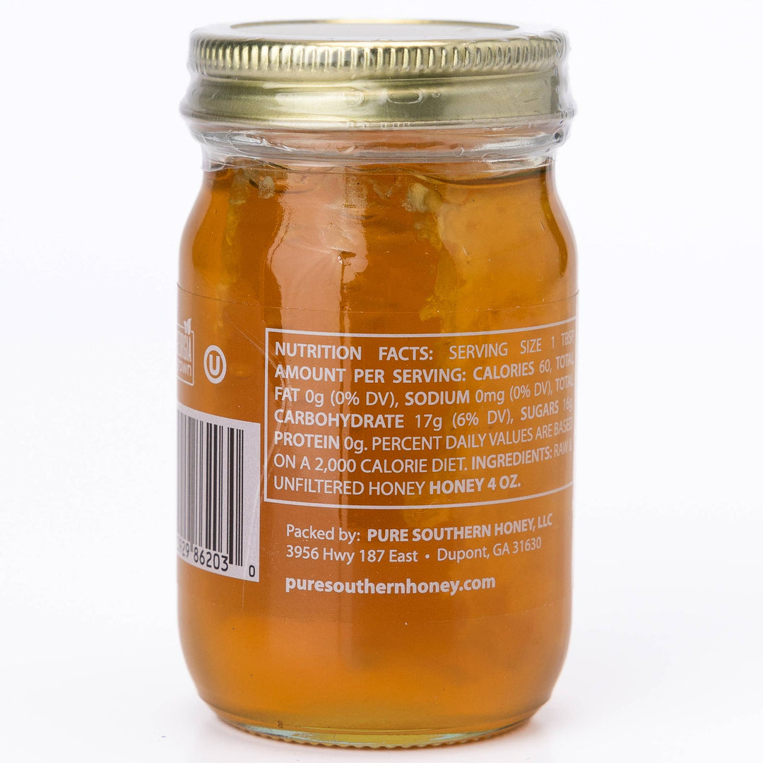 Jar of honey with a gold lid on a white background