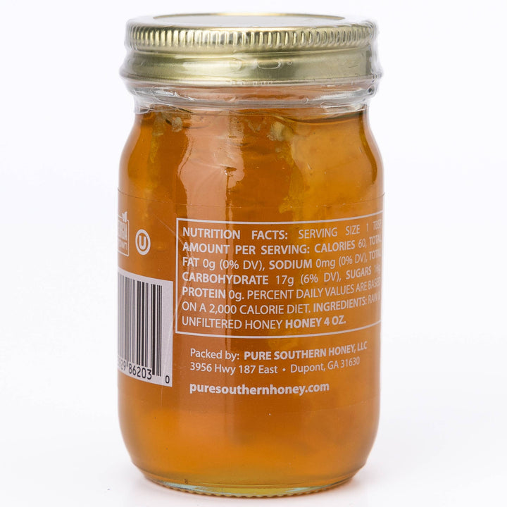 Jar of honey with a gold lid on a white background