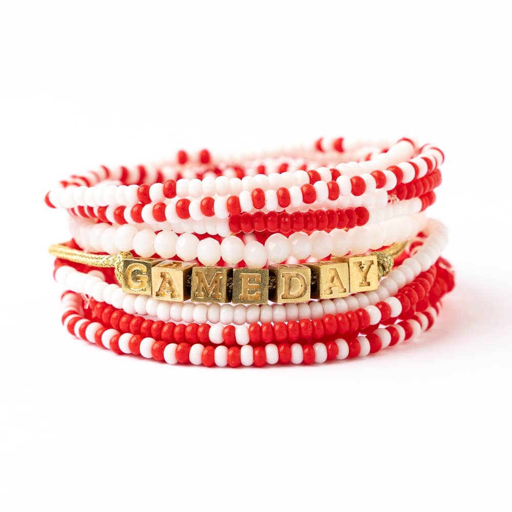 Stack of red and white beaded bracelets with a gold 'GAMEDAY' bracelet on a white background